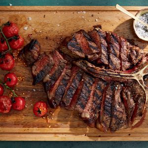 beautifully cooked porterhouse steak that has been cut in to strips