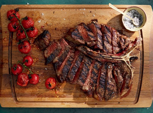 beautifully cooked porterhouse steak that has been cut in to strips
